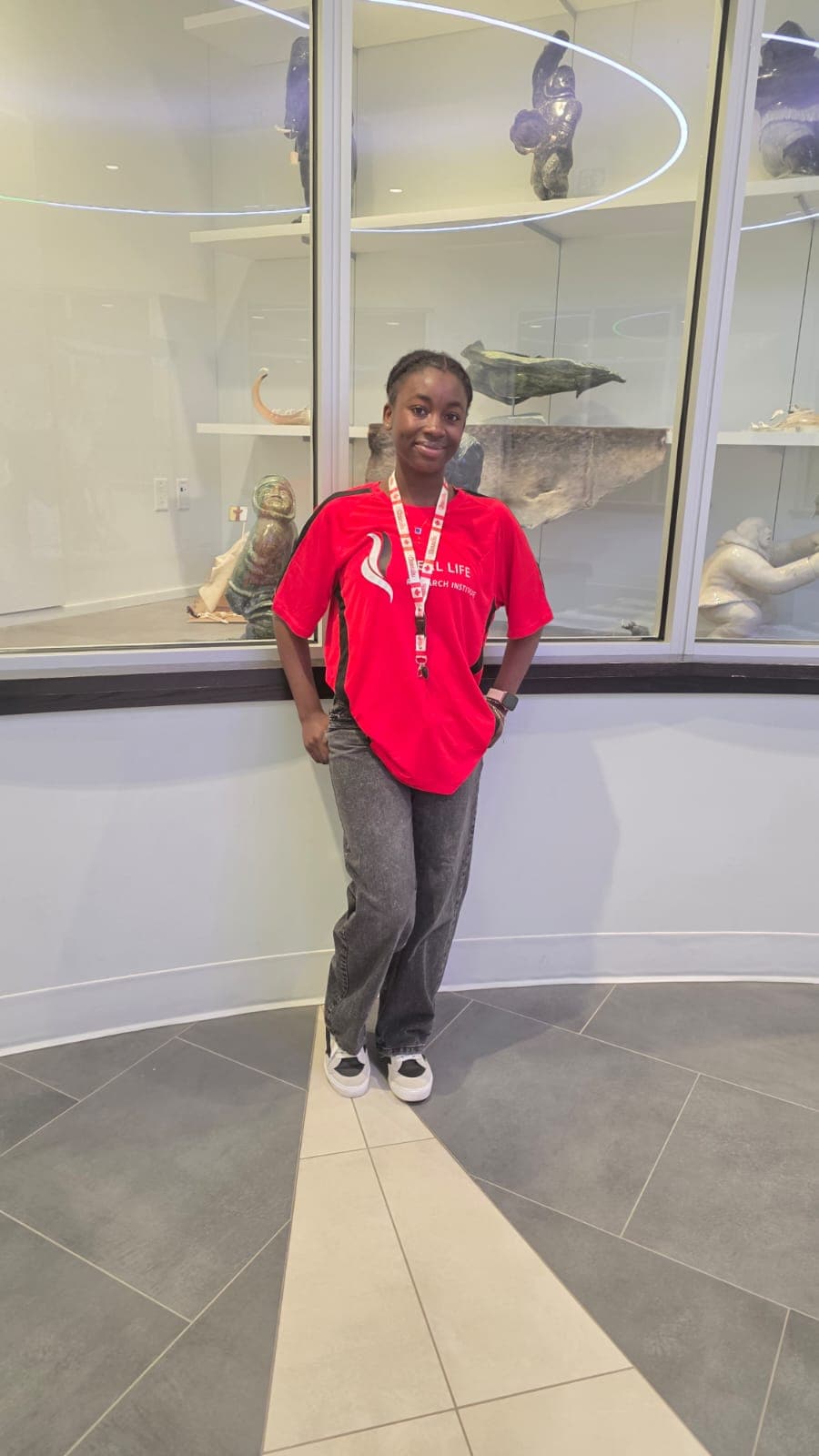 Student volunteer in a Real Life Institute t-shirt wearing a Canada lanyard