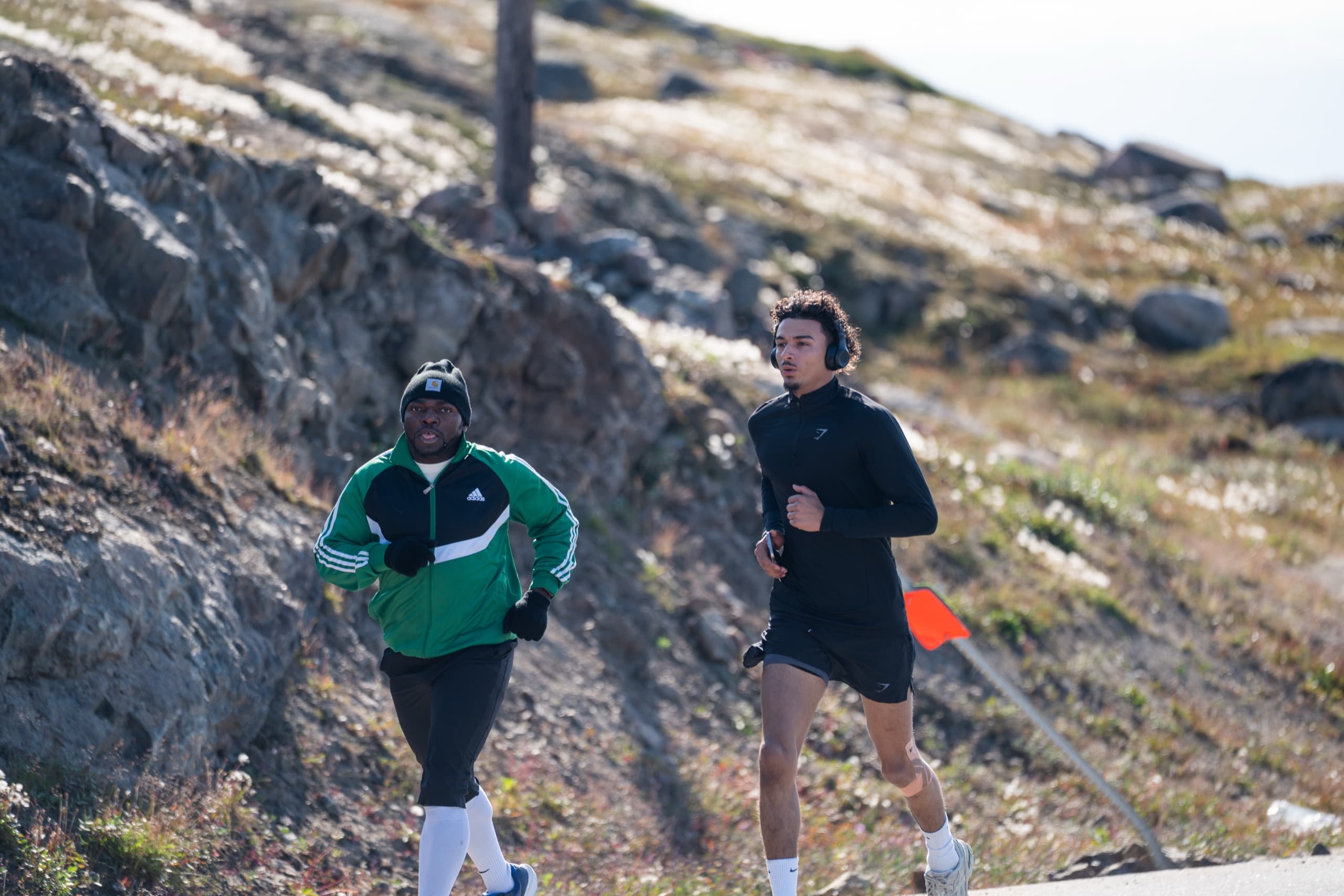 Two runners climbing a tundra road during the Love & Unity Run in Iqaluit