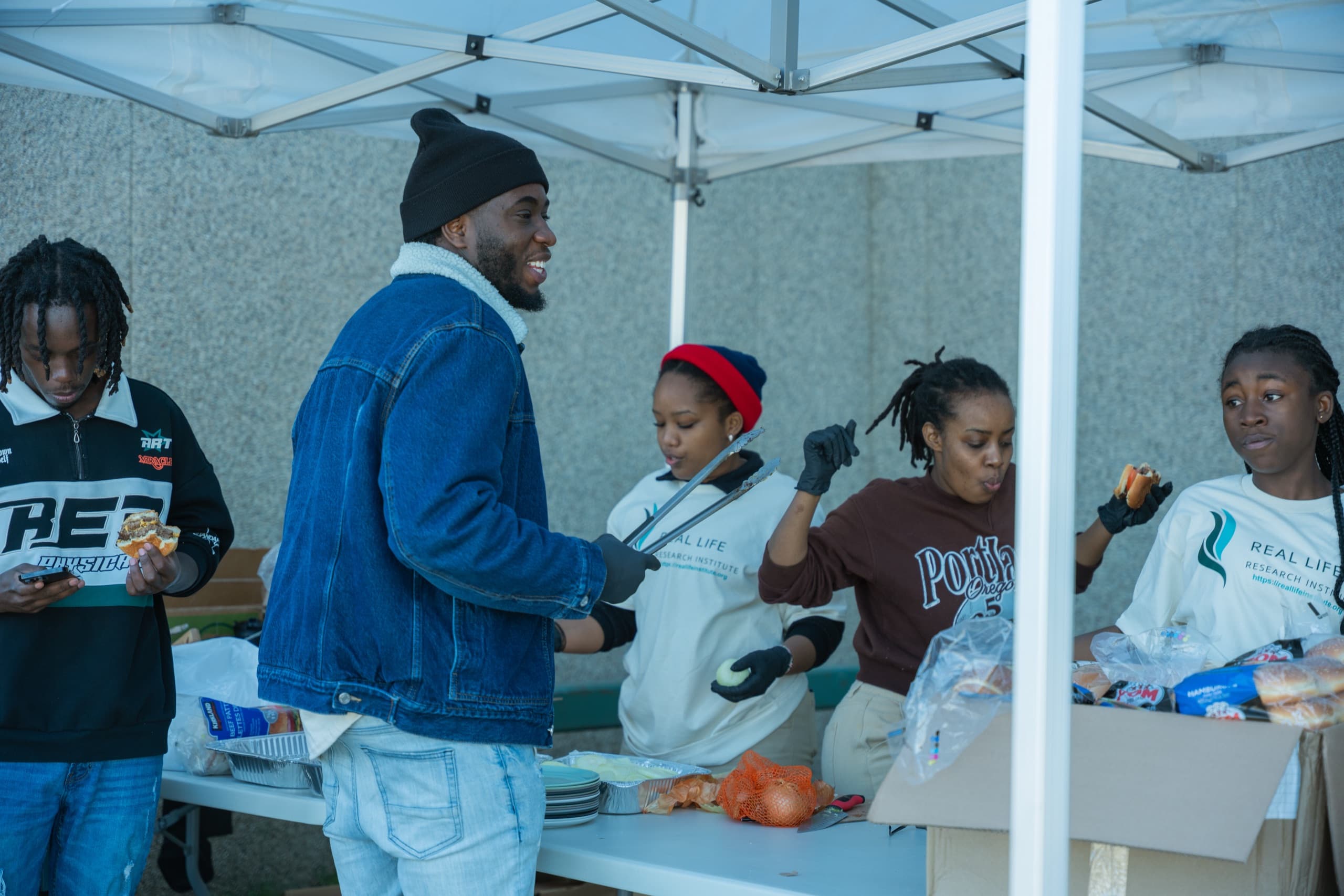 RLRI volunteers serving food together under an event tent